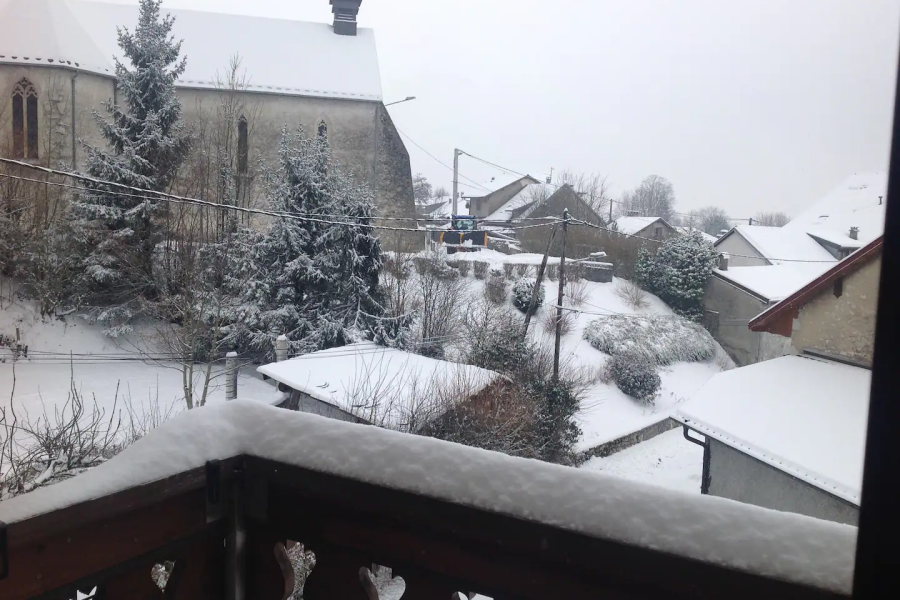 Le balcon enneigé et les toits du village de Confort